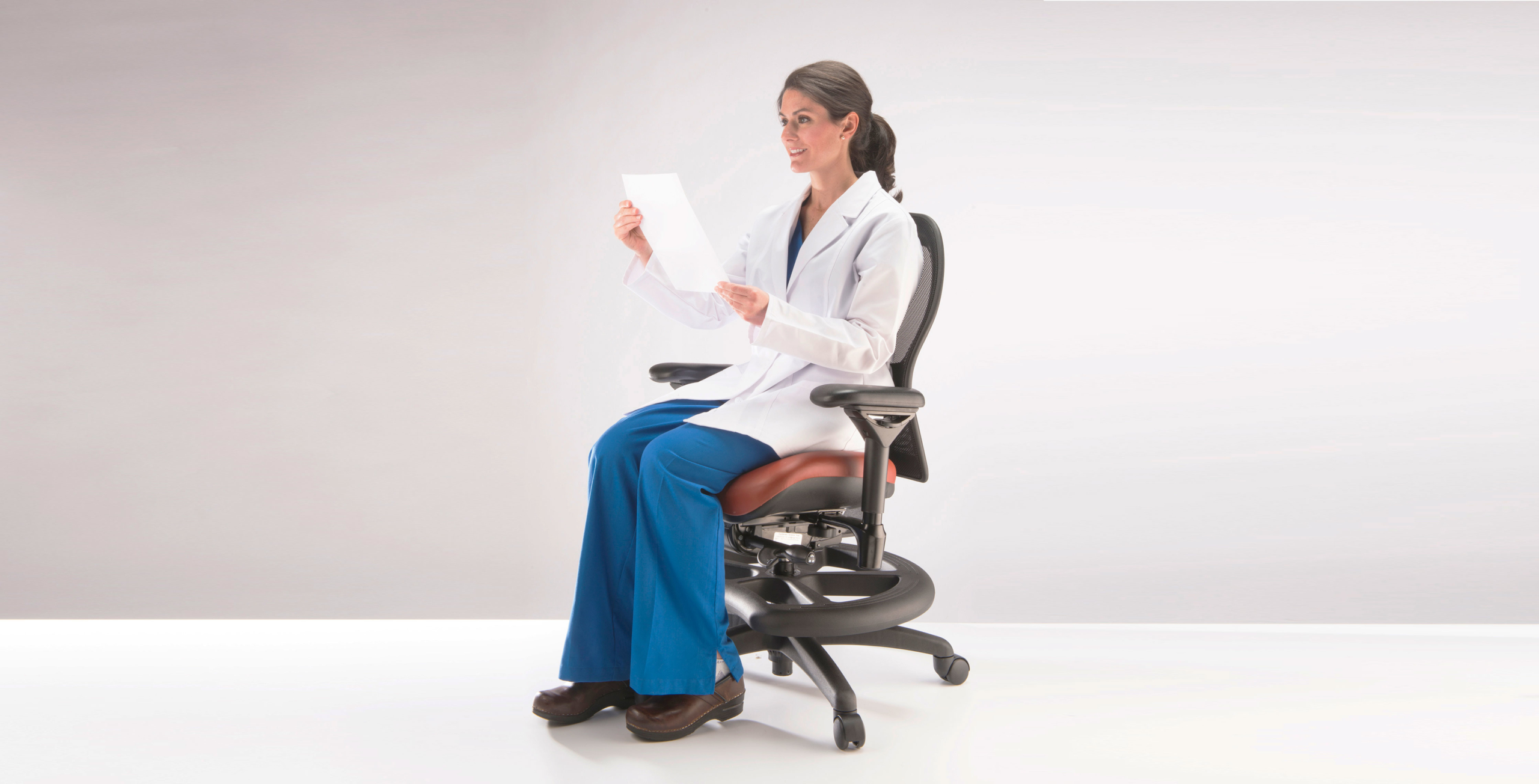 nurse sitting upright on chair to protect back at work